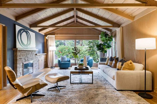 a living room with furniture a fireplace and a large window