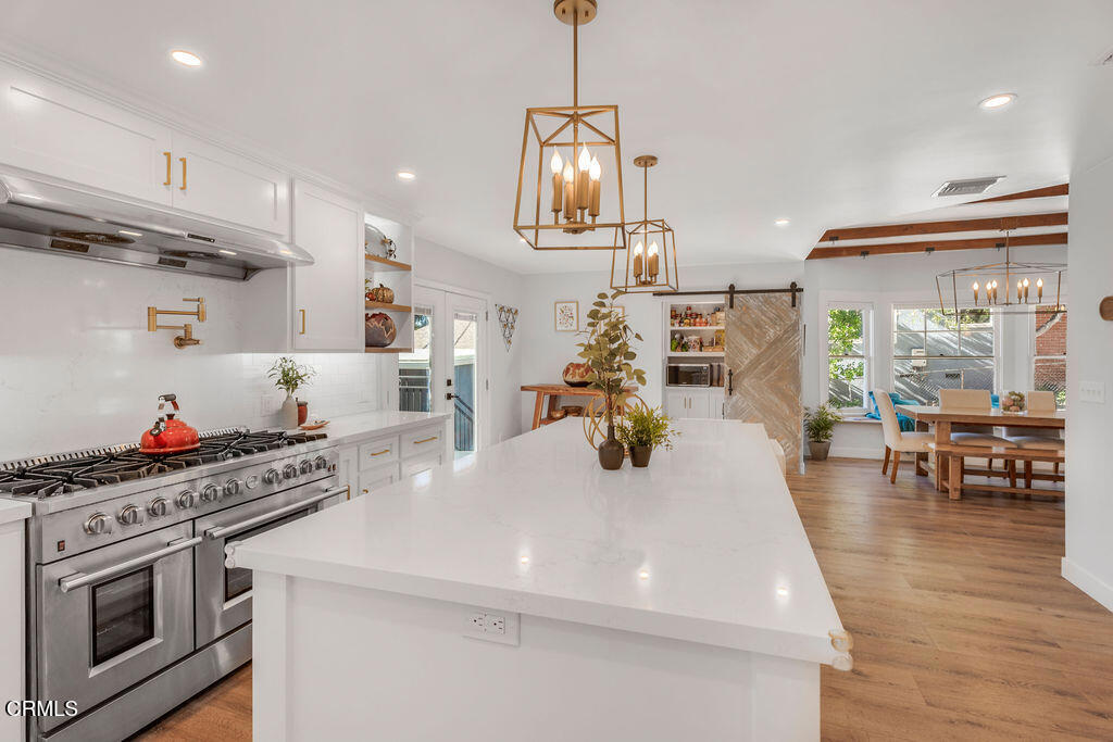 3500 Fairchild Street La Crescenta, CA 91214 - Photo 10 of 54 a kitchen view with stainless steel appliances a stove a sink a refrigerator and a dining table with wooden floor