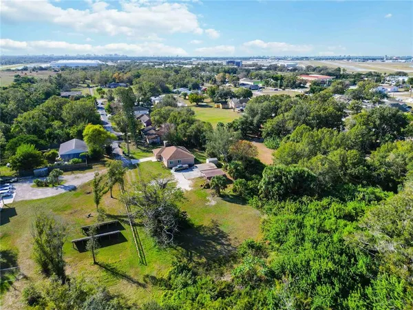 an aerial view of residential houses with outdoor space and trees