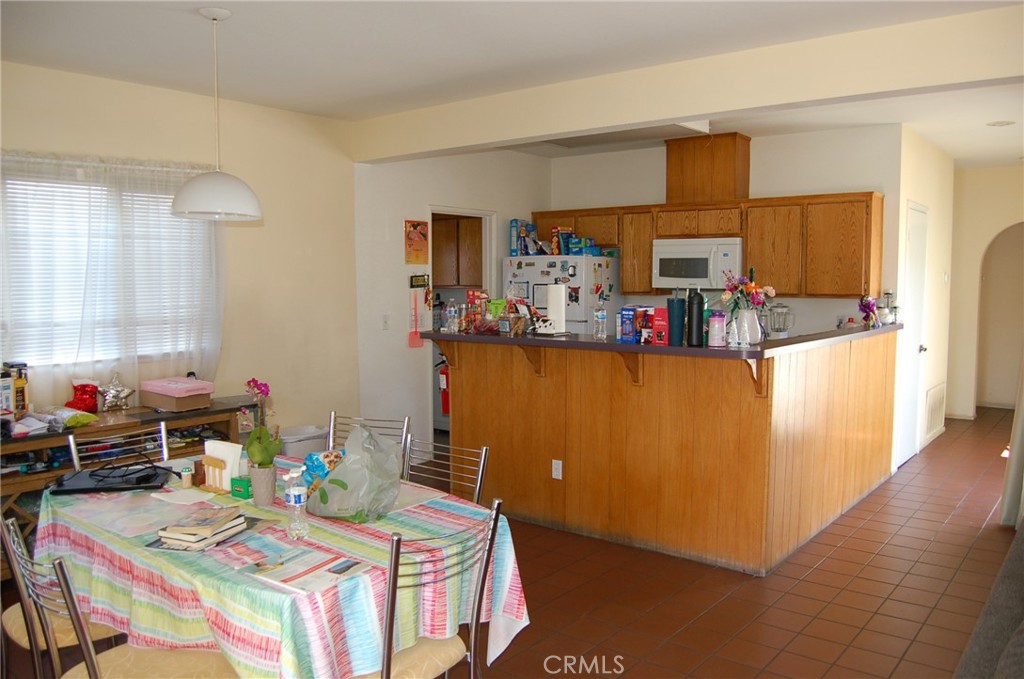 7731 Evans Street Riverside, CA 92504 - Photo 4 of 22 a room with furniture a flat screen tv and a dining table