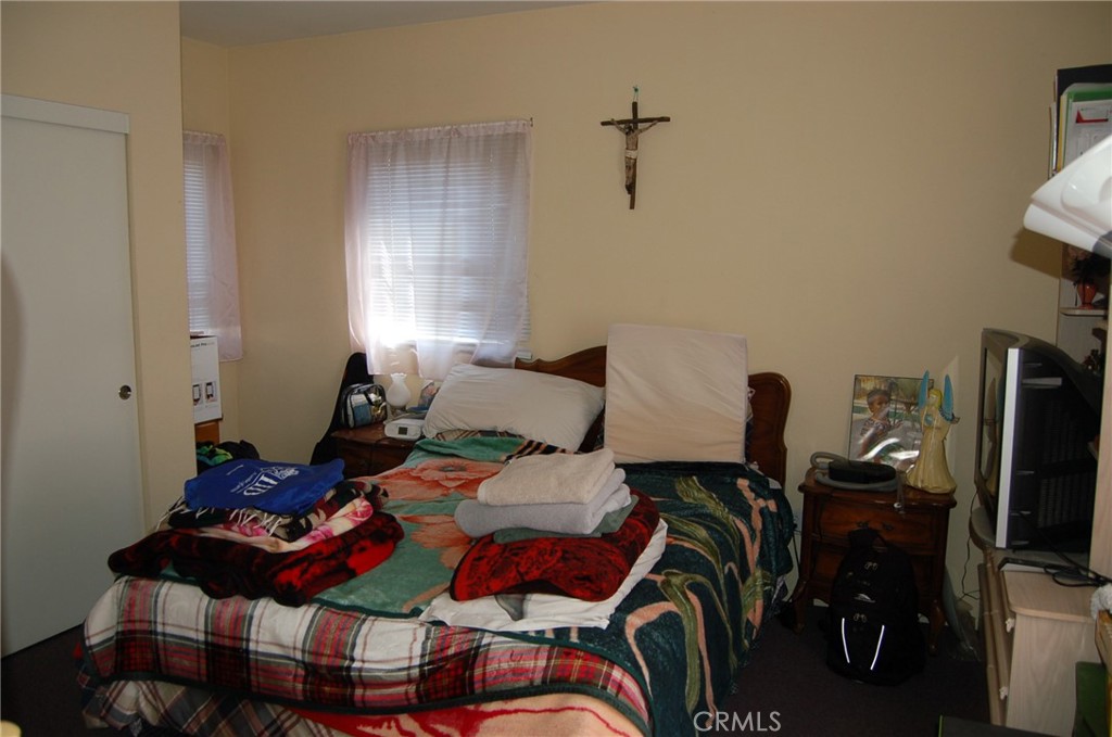 7731 Evans Street Riverside, CA 92504 - Photo 8 of 22 a bedroom with furniture and a flat screen tv