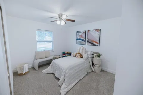 a bedroom with bed and a chandelier