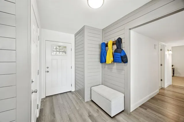 a view of a hallway with wooden floor and bathroom