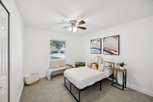 a bedroom with a bed and a chandelier fan