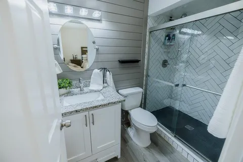 a bathroom with a granite countertop toilet sink and shower
