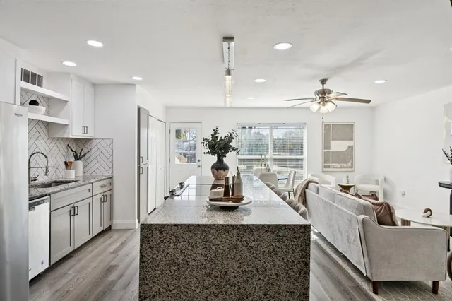 a kitchen with stainless steel appliances granite countertop a sink and a refrigerator