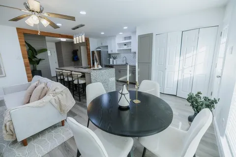 a living room with furniture kitchen view and a chandelier