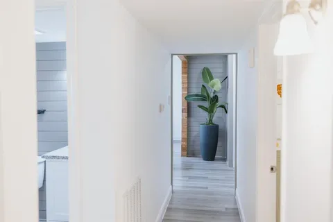 a view of a hallway with wooden floor and a dining room