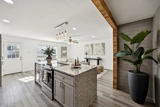 a open kitchen with stainless steel appliances granite countertop a stove and a wooden floors