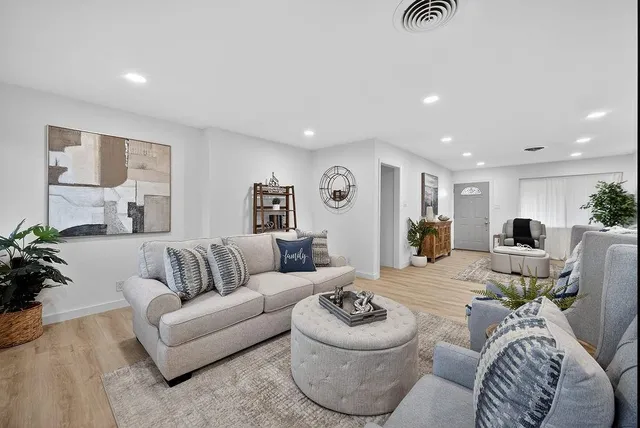 a living room with furniture and a wooden floor