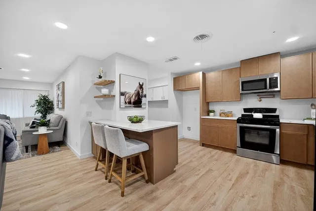 a kitchen with stainless steel appliances wooden floors and wooden cabinets