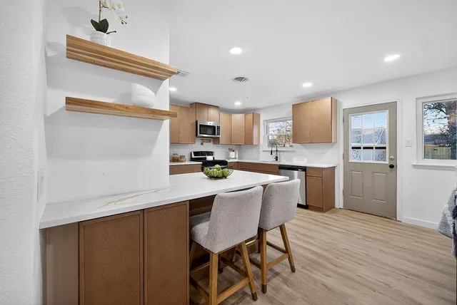a kitchen with a sink cabinets and wooden floor