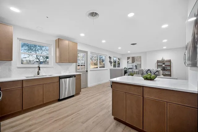 a kitchen with white cabinets and sink