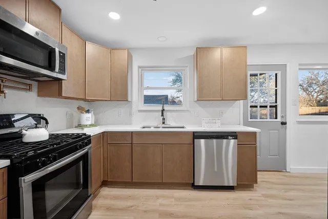 a kitchen with stainless steel appliances a sink stove and cabinets