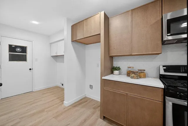 a kitchen with a sink cabinets and wooden floor