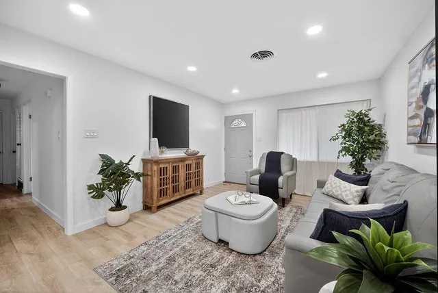 a living room with furniture potted plant and a bathroom