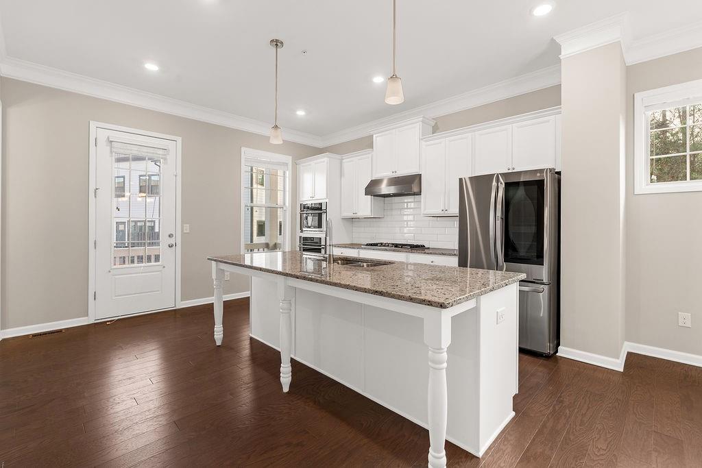 759 Topsail Lane Alpharetta, GA 30005 - Photo 19 of 50 a kitchen with stainless steel appliances granite countertop a refrigerator a stove a sink dishwasher and a refrigerator with wooden floor