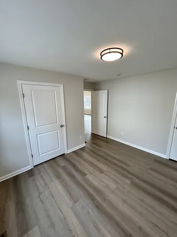 an empty room with wooden floor and window