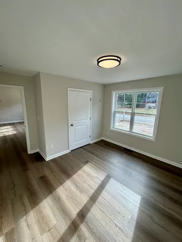 a view of a room with wooden floor and window