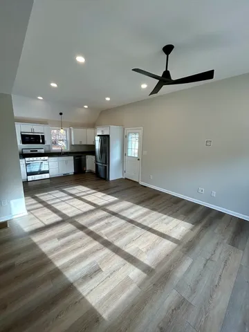 an empty space with kitchen view and a chandelier