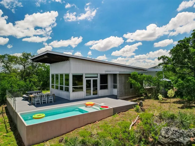 a view of a house with backyard and sitting area