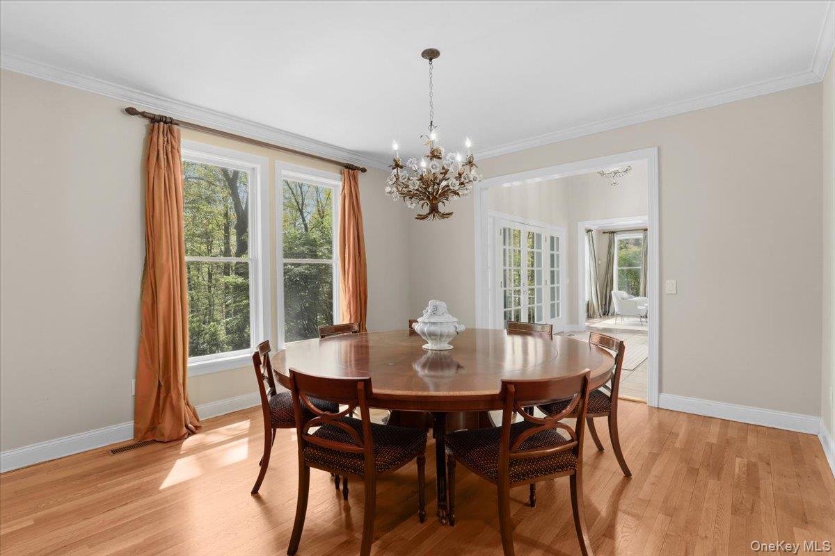 44 Scofield Road Pound Ridge, NY 10576 - Photo 12 of 36 a dining room with furniture a chandelier and wooden floor