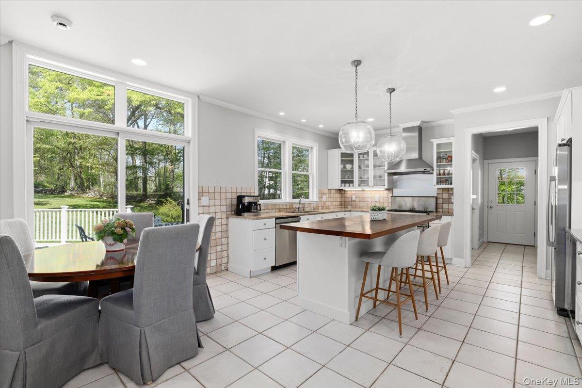 44 Scofield Road Pound Ridge, NY 10576 - Photo 9 of 36 a dining hall with stainless steel appliances kitchen island granite countertop a table chairs and a living room view