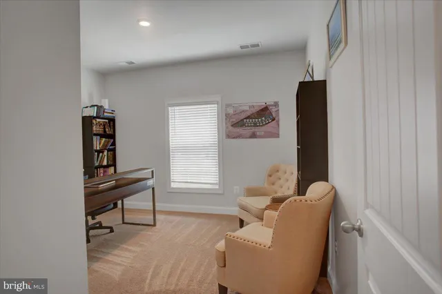 a view of a workspace with furniture and a window