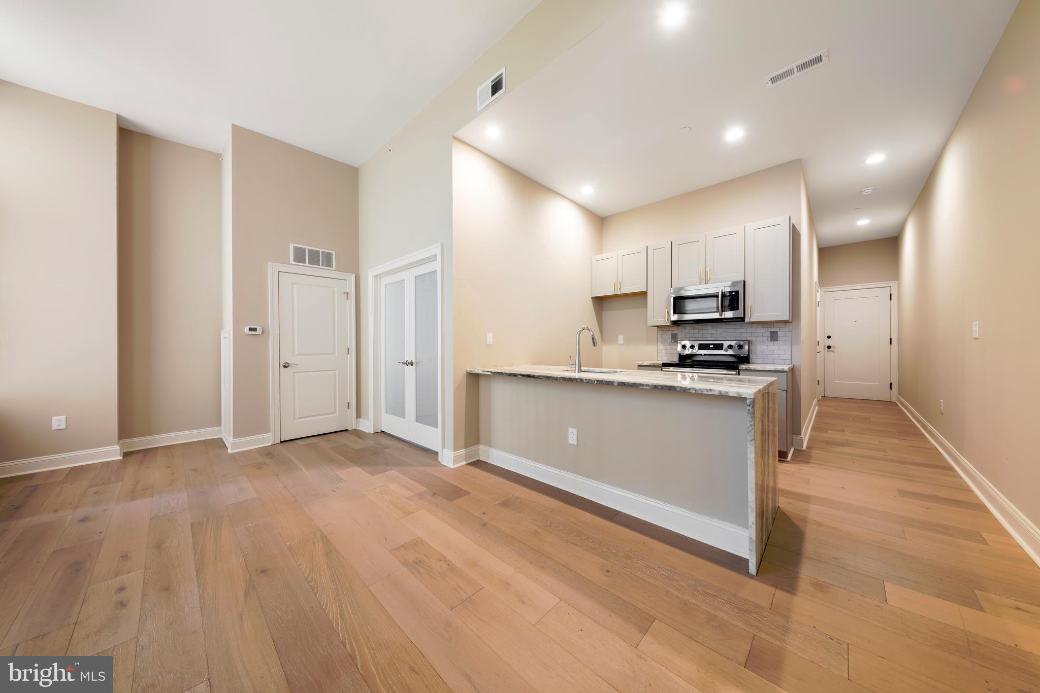 33 Letitia Street, Unit 306 Philadelphia, PA 19106 - Photo 14 of 24 a view of kitchen with kitchen island stainless steel appliances refrigerator stove microwave and cabinets