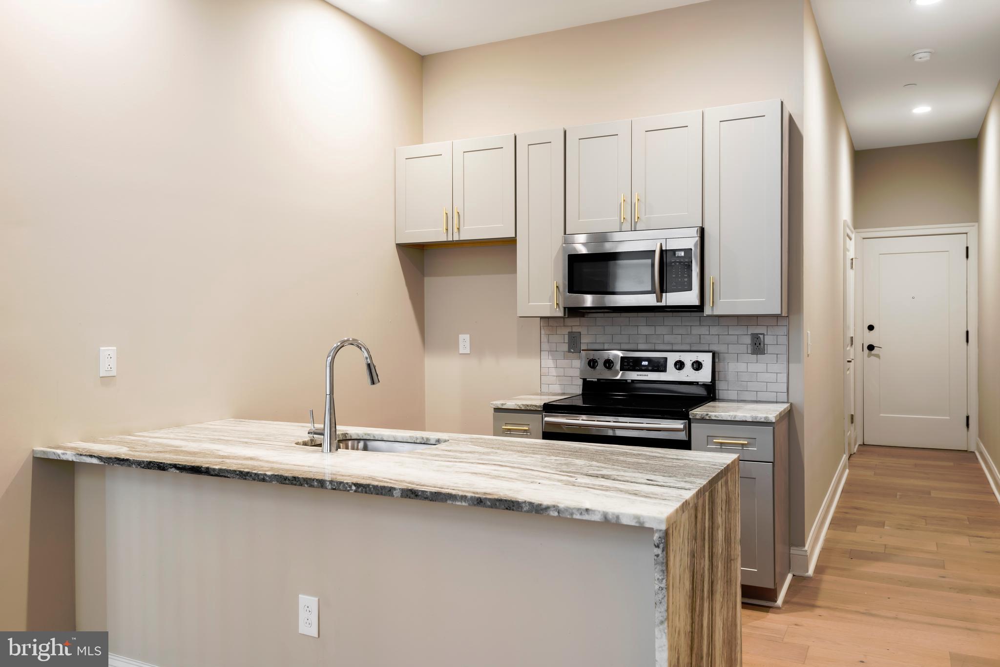 33 Letitia Street, Unit 306 Philadelphia, PA 19106 - Photo 15 of 24 a kitchen with stainless steel appliances a stove a sink and a microwave
