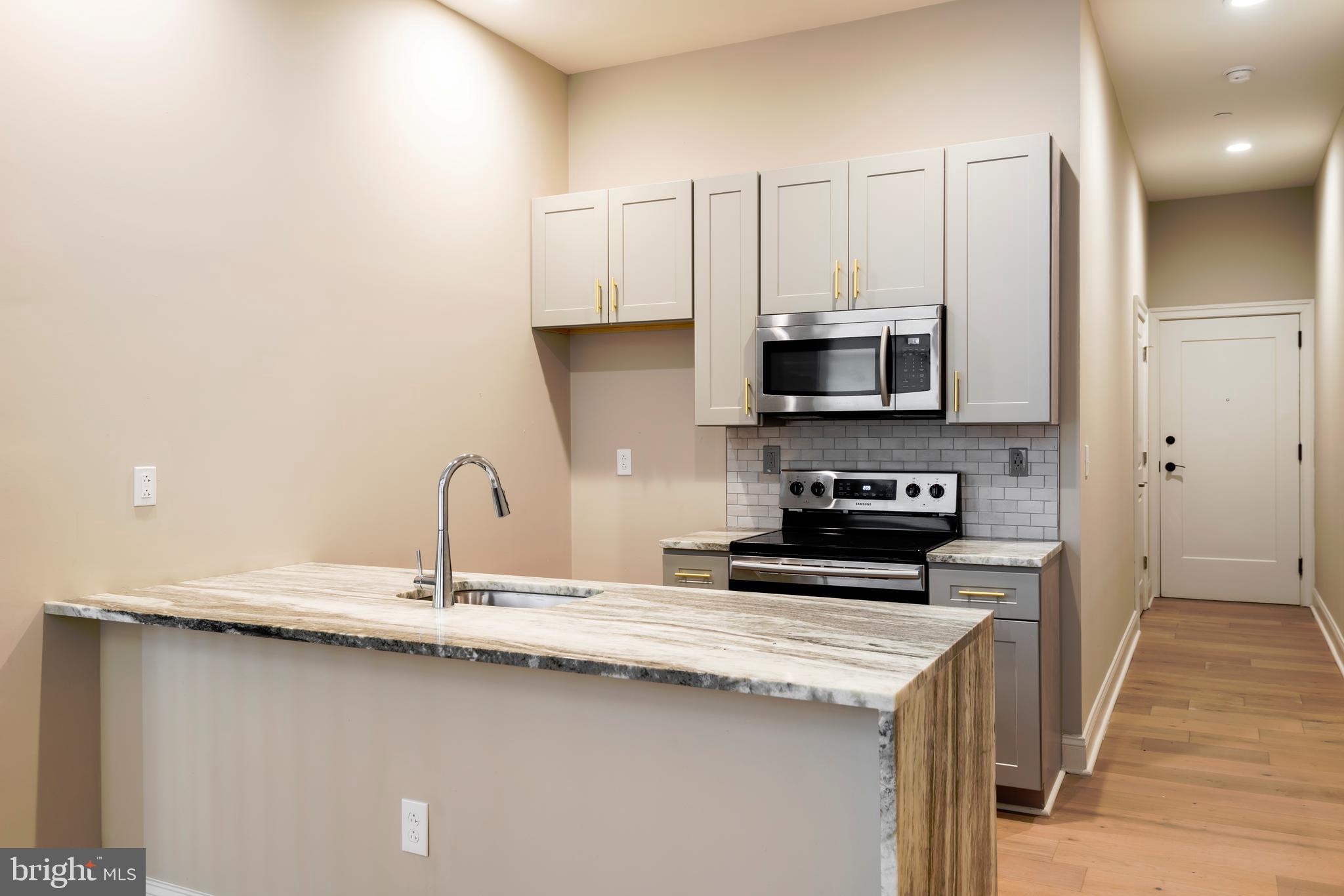 33 Letitia Street, Unit 306 Philadelphia, PA 19106 - Photo 16 of 24 a kitchen with stainless steel appliances a stove a sink and a microwave