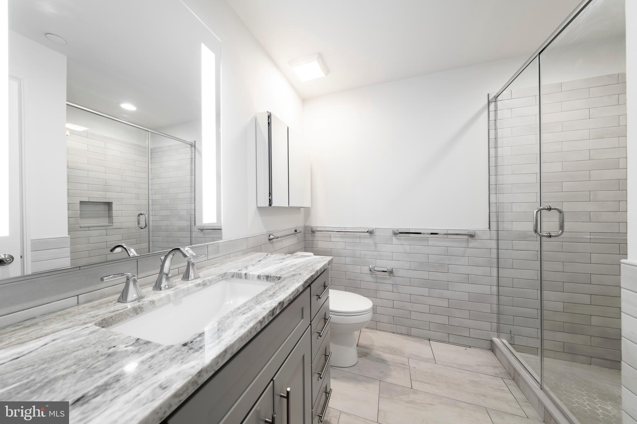 33 Letitia Street, Unit 306 Philadelphia, PA 19106 - Photo 23 of 24 a bathroom with a granite countertop sink a toilet and mirror