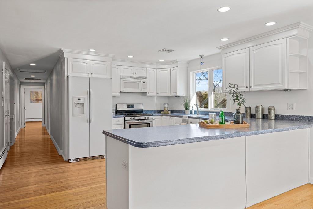 23 Williams Road Concord, MA 01742 - Photo 1 of 32 a kitchen with stainless steel appliances granite countertop a refrigerator a sink a stove and white cabinets with wooden floor