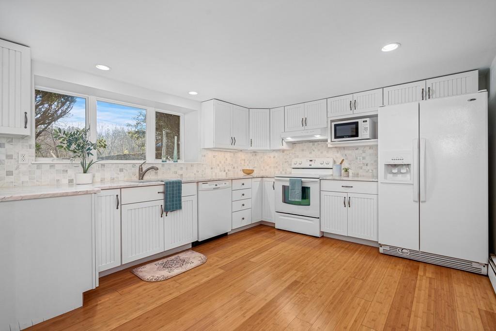 23 Williams Road Concord, MA 01742 - Photo 21 of 32 a kitchen with stainless steel appliances white cabinets and wooden floors