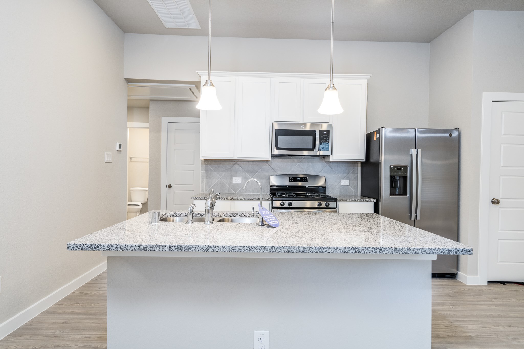 17536 Rosewood Manor Lane New Caney, TX 77357 - Photo 7 of 27 a kitchen with stainless steel appliances granite countertop a sink a stove a refrigerator a center island and cabinets