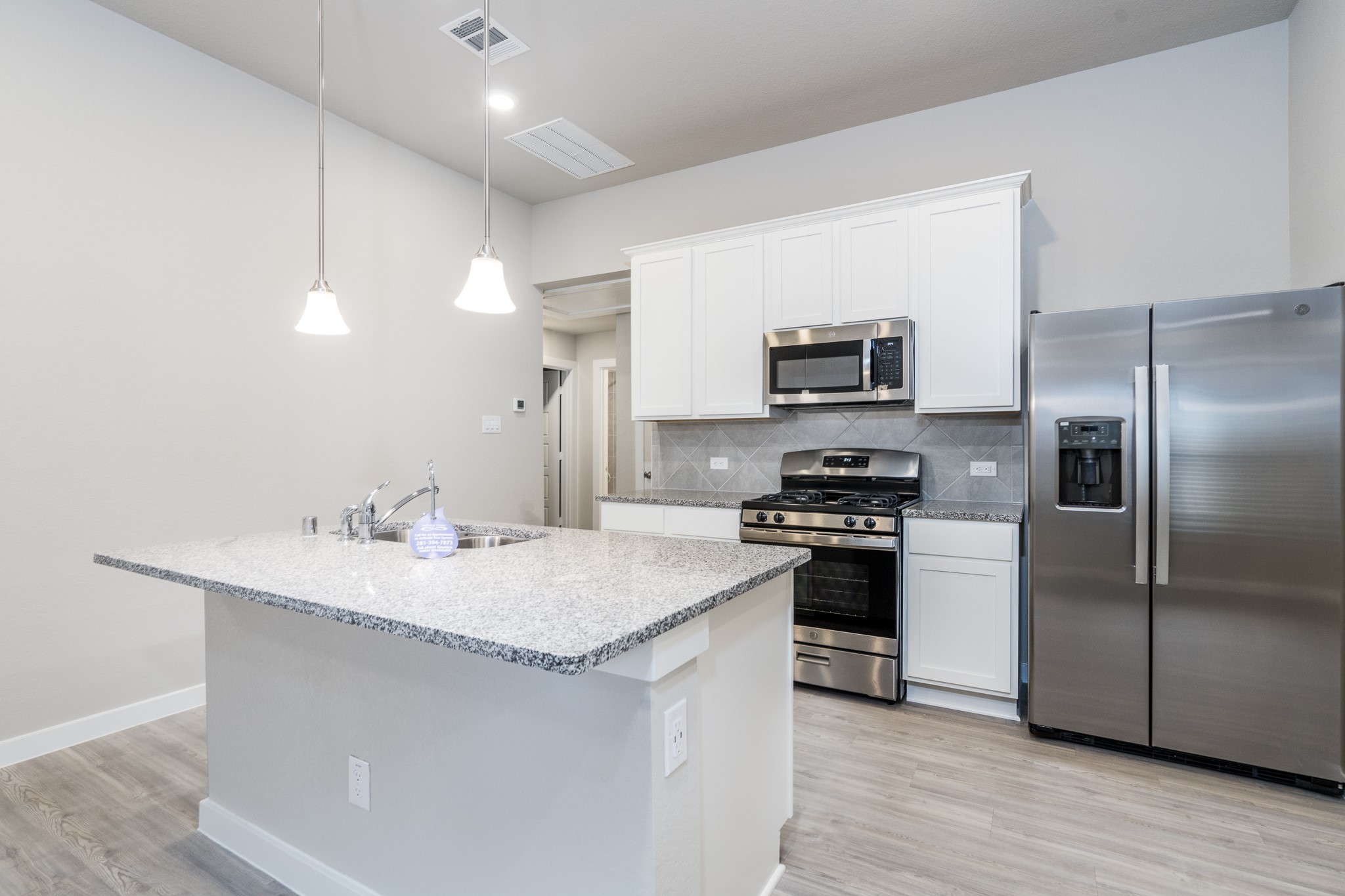 17536 Rosewood Manor Lane New Caney, TX 77357 - Photo 8 of 27 a kitchen with stainless steel appliances granite countertop a sink stove and refrigerator