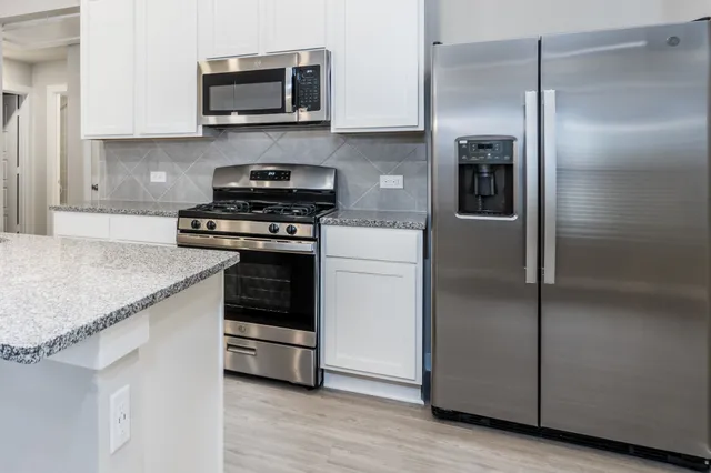 a kitchen with stainless steel appliances granite countertop a stove and a refrigerator