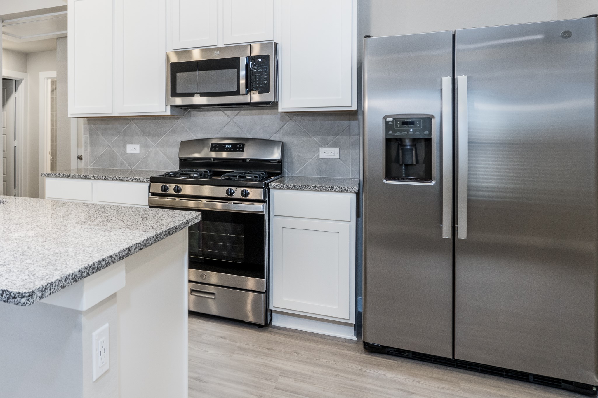 17536 Rosewood Manor Lane New Caney, TX 77357 - Photo 9 of 27 a kitchen with stainless steel appliances granite countertop a stove and a refrigerator