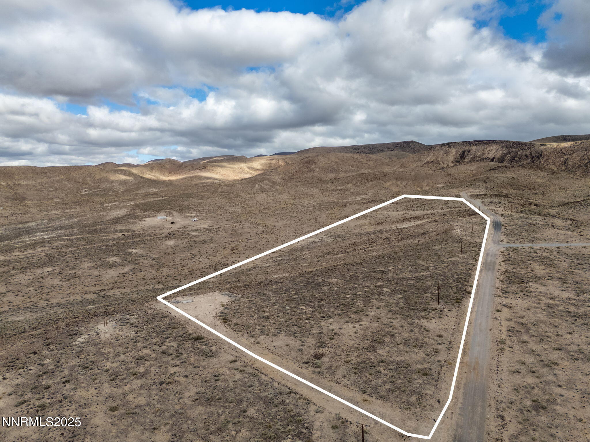a view of a dry yard with wooden fence