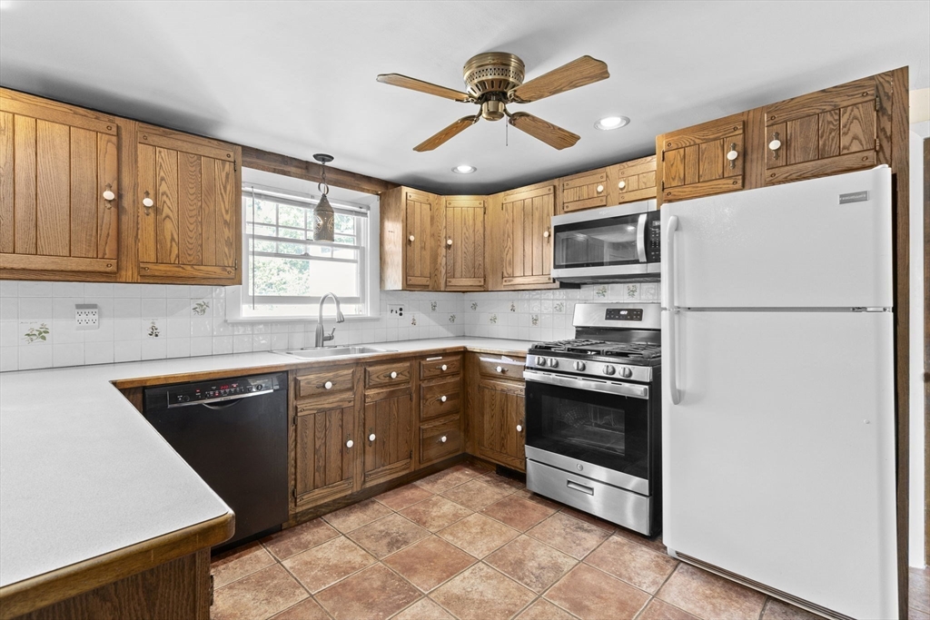 107 Tilden Road Scituate, MA 02066 - Photo 10 of 38 a kitchen with stainless steel appliances granite countertop a refrigerator a sink a stove a microwave and island