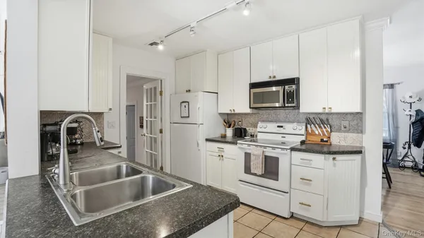 a kitchen with white cabinets and stainless steel appliances