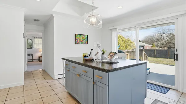 a kitchen with a sink a counter top space and living room view