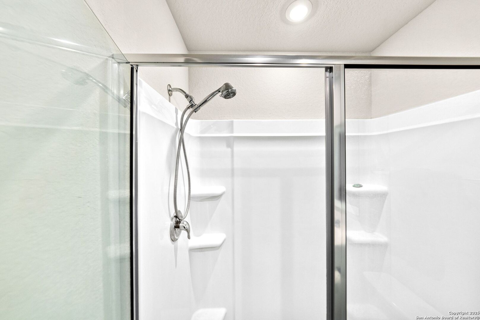 19911 Wyatt Earp Way Lytle, TX 78052 - Photo 17 of 26 a bathroom with a glass shower door and a shower