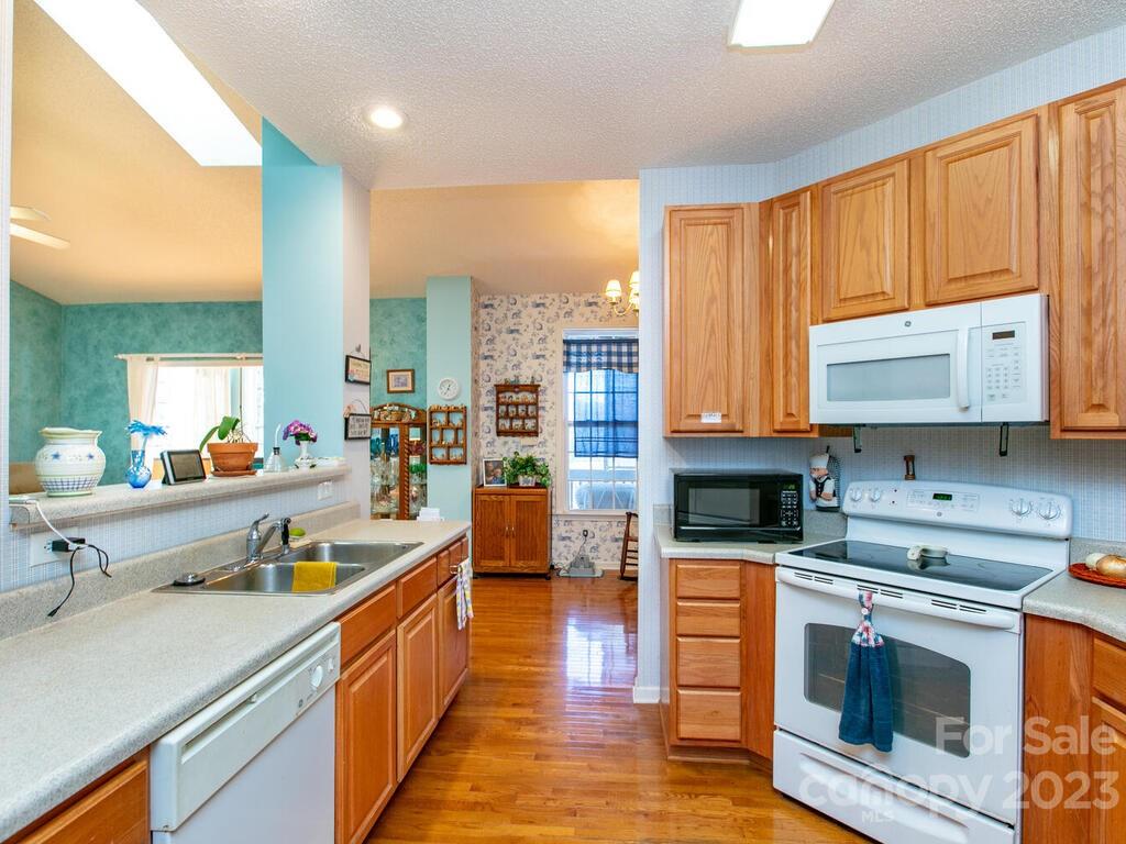 256 Walnut Crest Road Fletcher, NC 28732 - Photo 12 of 38 a large kitchen with stainless steel appliances granite countertop a stove a sink and a microwave