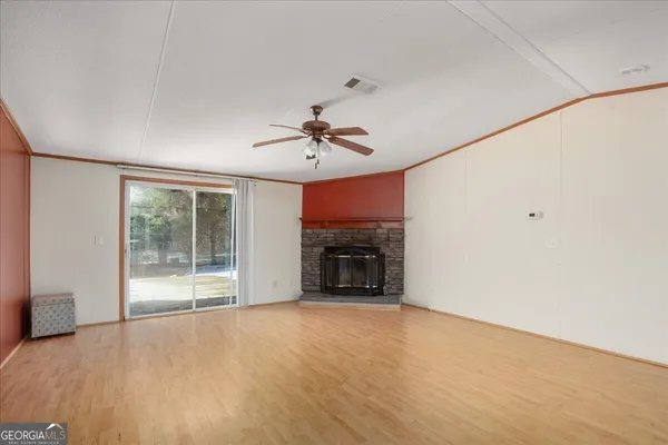 an empty room with windows and fireplace