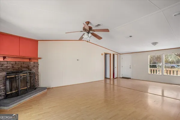 a view of a livingroom with a ceiling fan kitchen stove and a window