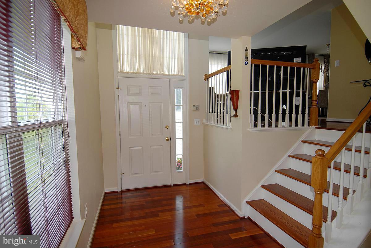 44047 Rising Sun Terrace Ashburn, VA 20147 - Photo 2 of 30 a view of a hallway with wooden floor and staircase