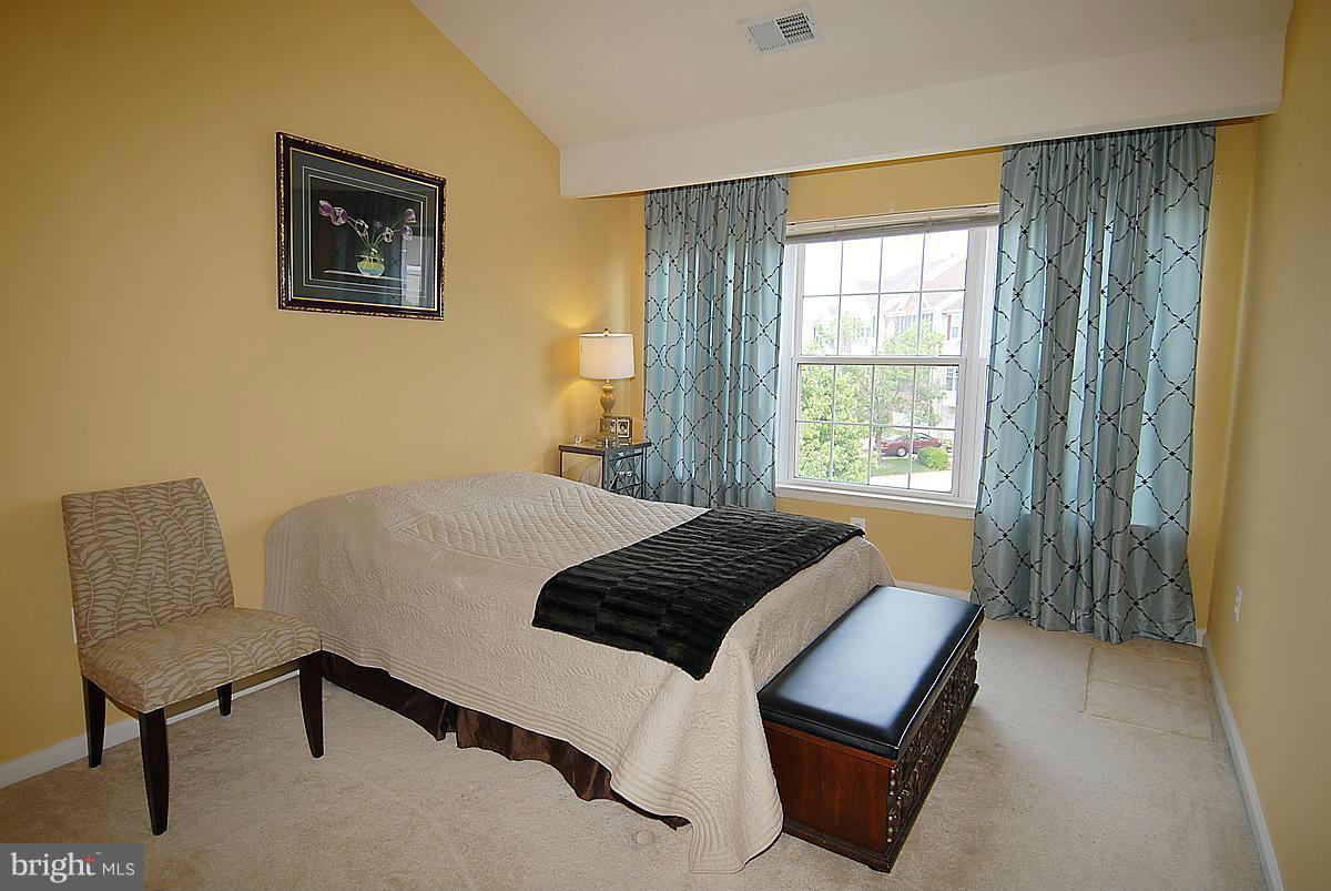 44047 Rising Sun Terrace Ashburn, VA 20147 - Photo 28 of 30 a bedroom with a bed and a chair