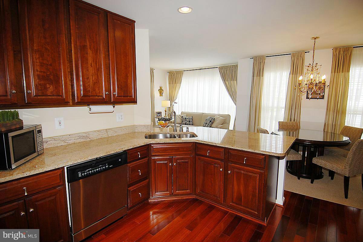 44047 Rising Sun Terrace Ashburn, VA 20147 - Photo 6 of 30 a kitchen with stainless steel appliances granite countertop wooden cabinets a sink and dishwasher with wooden floor