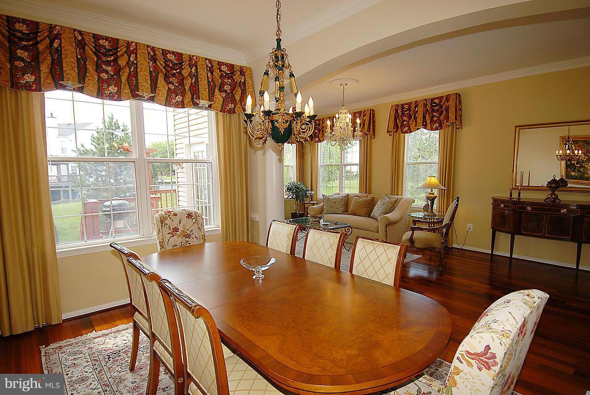 44047 Rising Sun Terrace Ashburn, VA 20147 - Photo 8 of 30 a dining room with furniture a chandelier and wooden floor